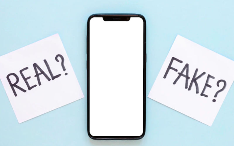 Image of cellphone with Real? or Fake post-it notes next to it